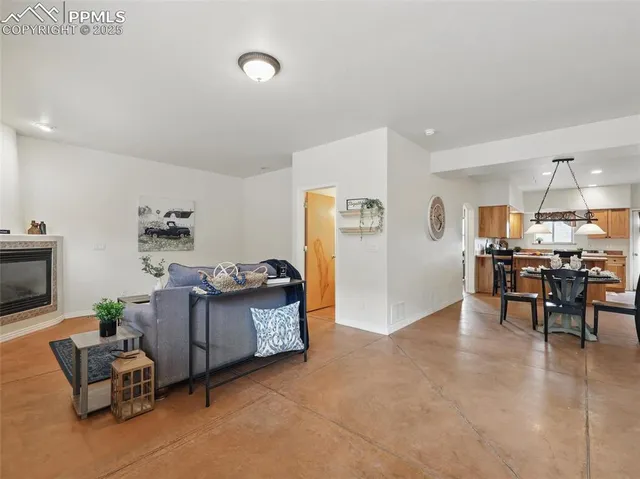 a living room with furniture and a dining table with kitchen view