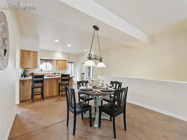 a view of a dining room with furniture and kitchen view