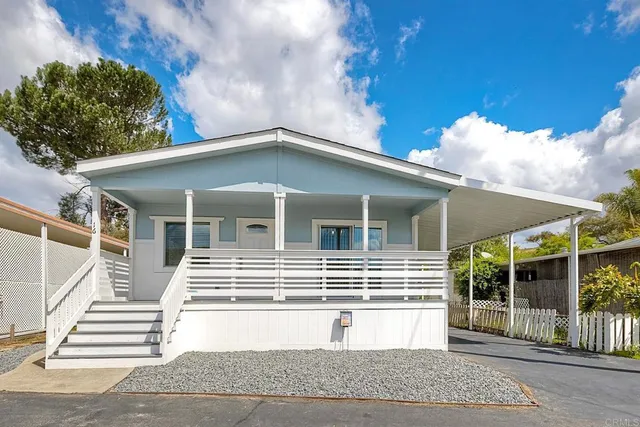a view of a house with a yard and potted plants
