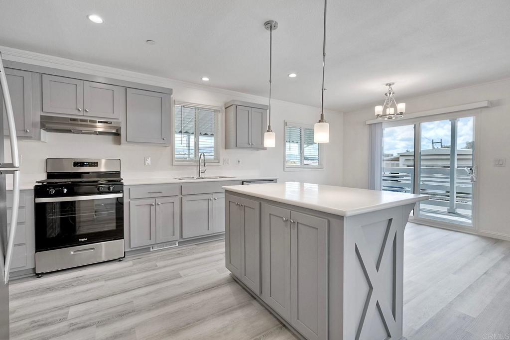 28890 Lilac Road Valley Center, CA 92082 - Photo 13 of 57 a kitchen with stainless steel appliances granite countertop a sink a stove a refrigerator and island with wooden floor