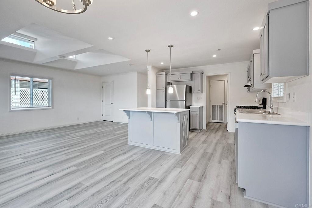 28890 Lilac Road Valley Center, CA 92082 - Photo 15 of 57 a large kitchen with a center island wooden floor stainless steel appliances and cabinets