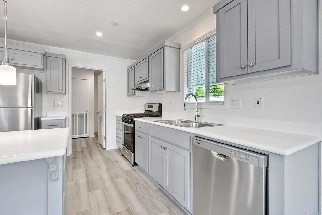 28890 Lilac Road Valley Center, CA 92082 - Photo 18 of 57 a kitchen with white cabinets and appliances