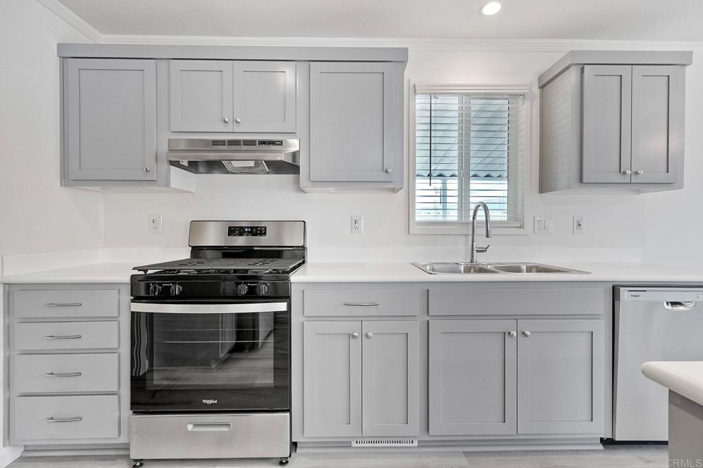 28890 Lilac Road Valley Center, CA 92082 - Photo 19 of 57 a kitchen with white cabinets and appliances