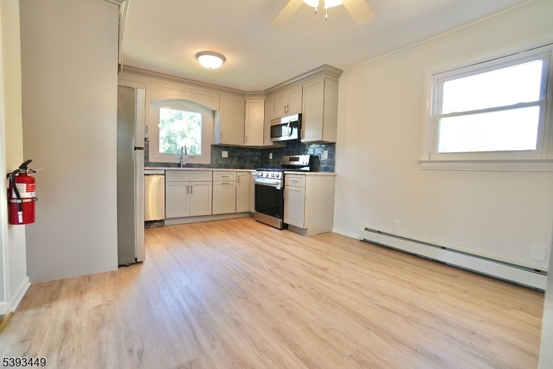 15 Wright Court, Unit 2 Bloomfield, NJ 07003 - Photo 4 of 13 a kitchen with granite countertop a stove a sink and a refrigerator