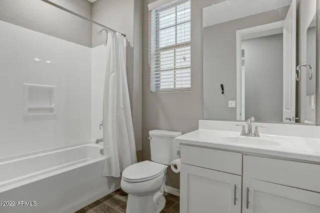 a view of an empty room and chandelier fan