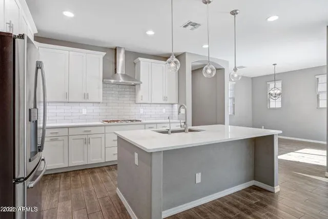 a kitchen with kitchen island a sink appliances a counter space and a window