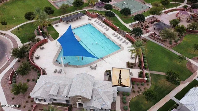 a swimming pool with lots of green space and trees in the background
