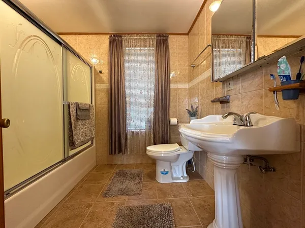 a kitchen with stainless steel appliances a stove a sink dishwasher with a dining table and chair