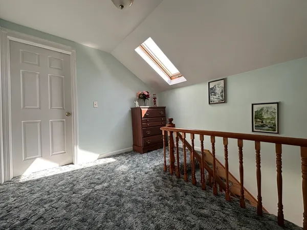 a bed sitting in a bedroom next to a window and dresser