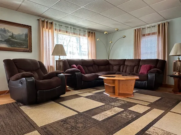 a living room with furniture a flat screen tv and a large window