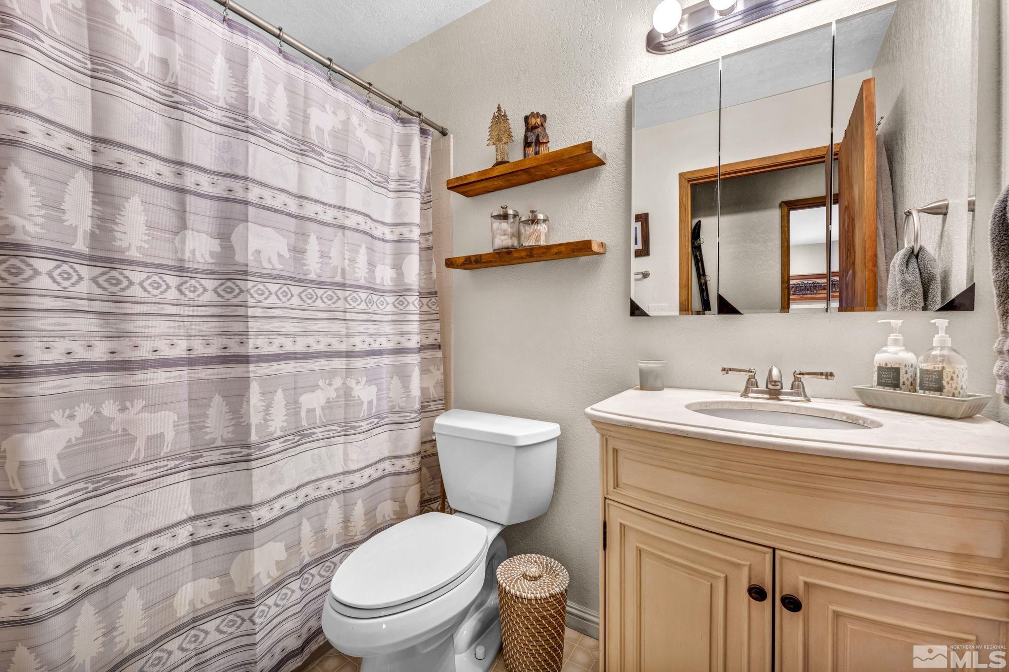 445 Andria Drive Stateline, NV 89449 - Photo 28 of 36 a bathroom with a granite countertop toilet sink and mirror