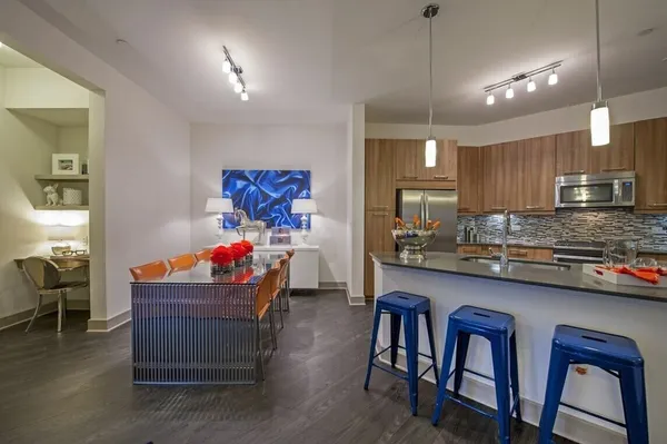 a room with granite countertop lots of wooden furniture and stainless steel appliances
