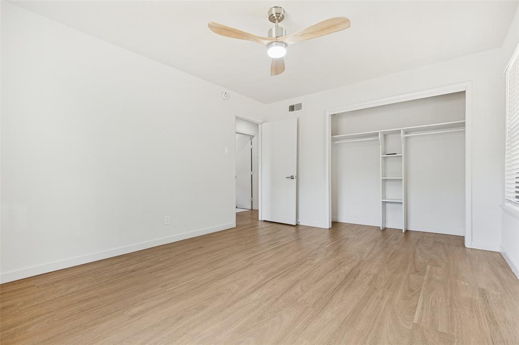 1215 Fordham Road Dallas, TX 75216 - Photo 17 of 25 Wood-finish flooring, white walls, ceiling fan with integrated lighting, built-in closet shelving, and a window with horizontal blinds