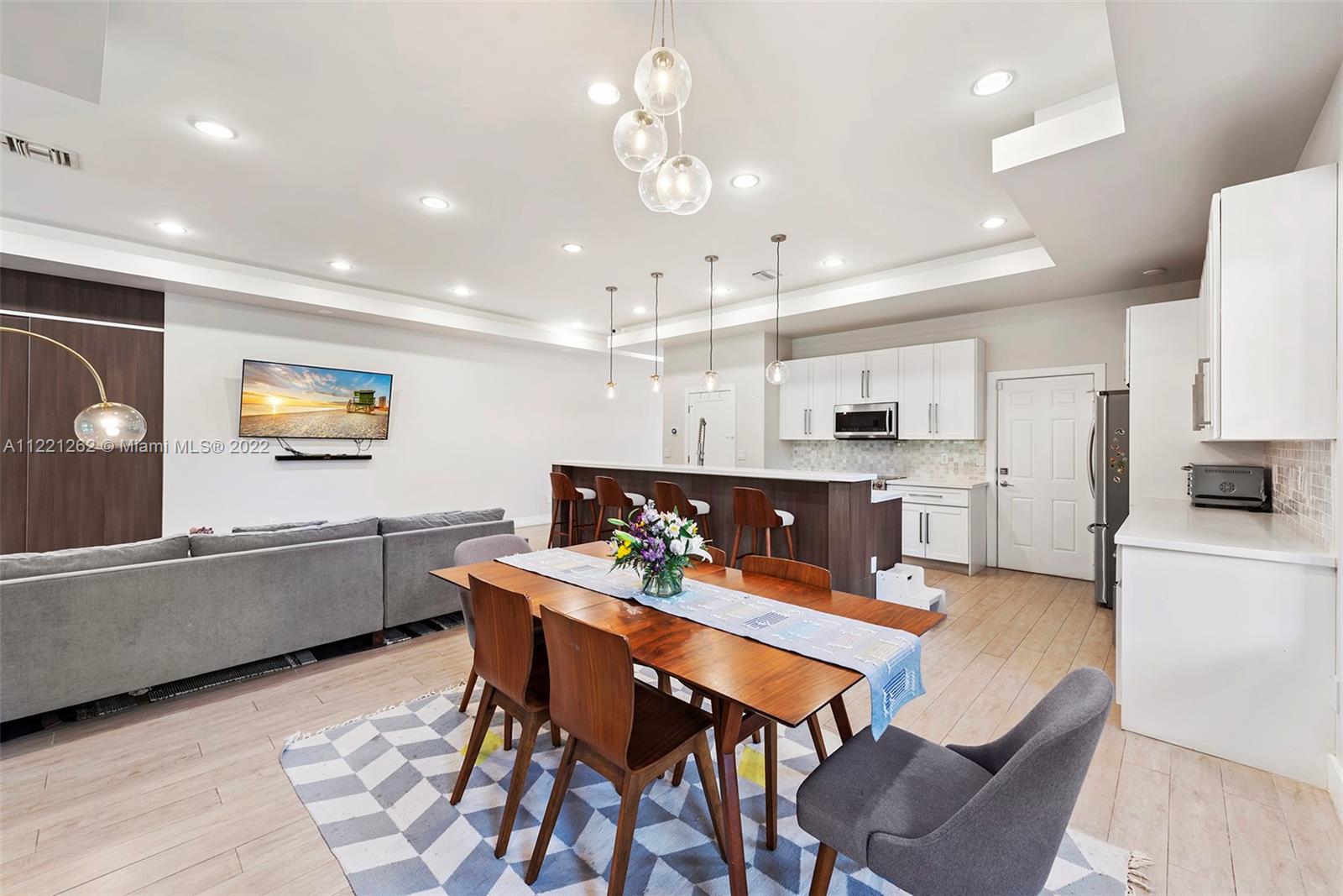 2321 Southwest 19th Street Miami, FL 33145 - Photo 5 of 29 a kitchen with stainless steel appliances kitchen island granite countertop a dining table chairs and a refrigerator