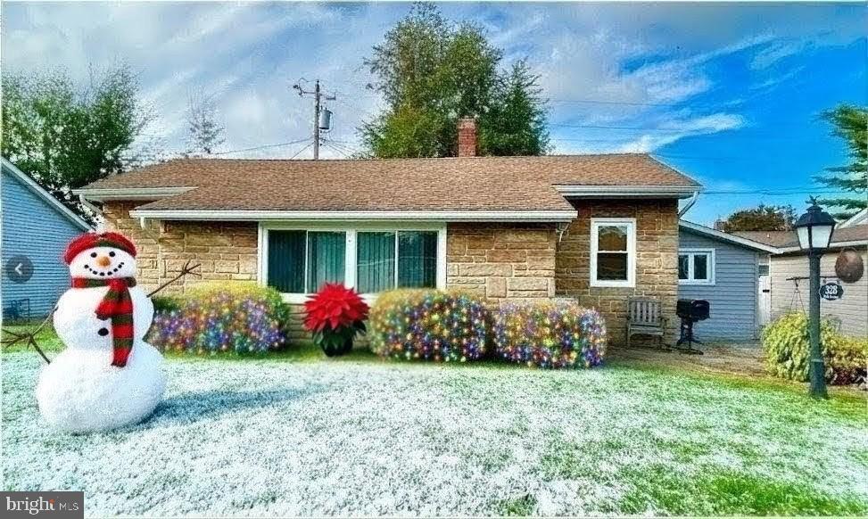 a front view of a house with lots of flowers