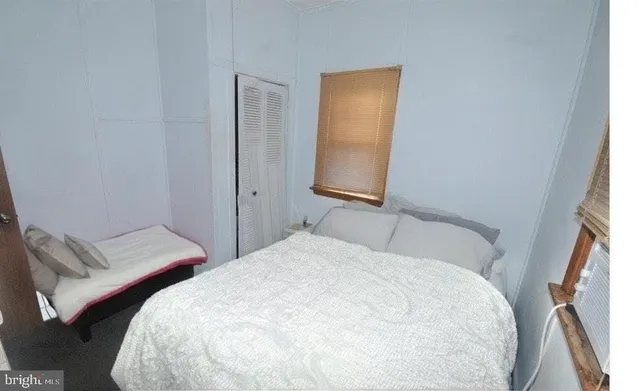 a bedroom with a bed and a window