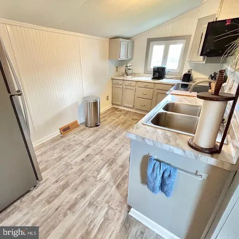 a kitchen with sink a refrigerator and cabinets