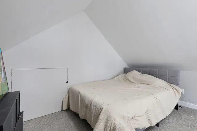 a large bed sitting in a bedroom next to a window