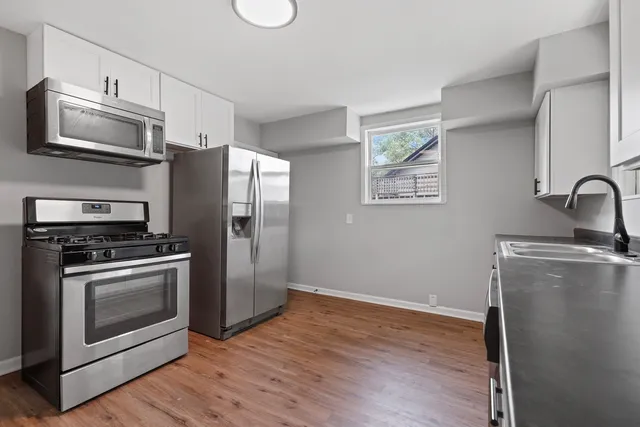 a kitchen with granite countertop a refrigerator stove and microwave