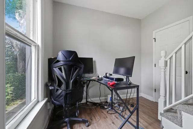 a view of a workspace with furniture and a window