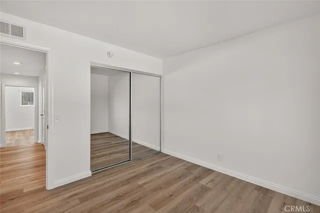 a view of wooden floor and closet in a room