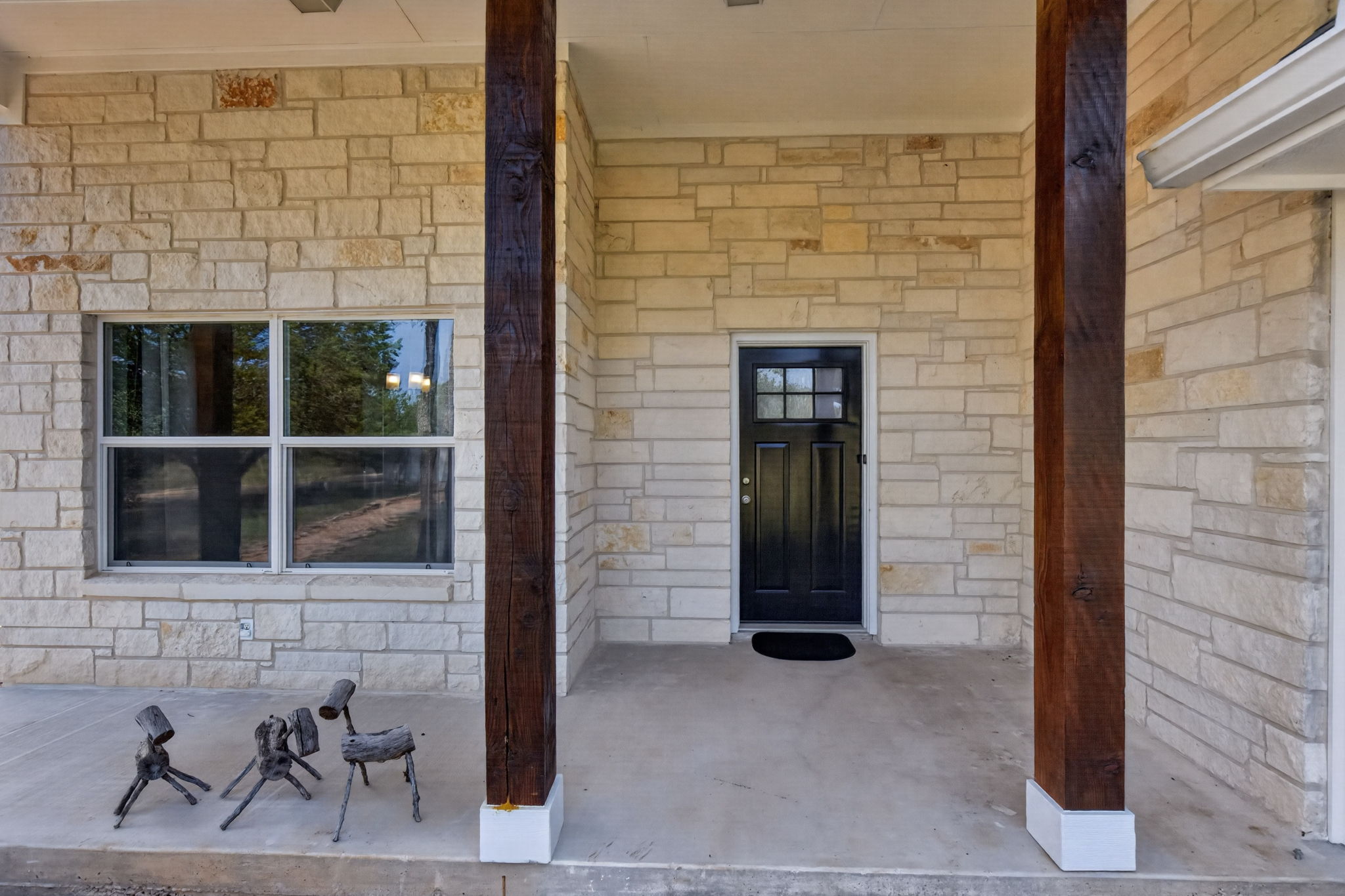 207 Deer Ridge Drive Burnet, TX 78611 - Photo 5 of 36 A welcoming front entrance featuring rustic timber columns and a classic black door.