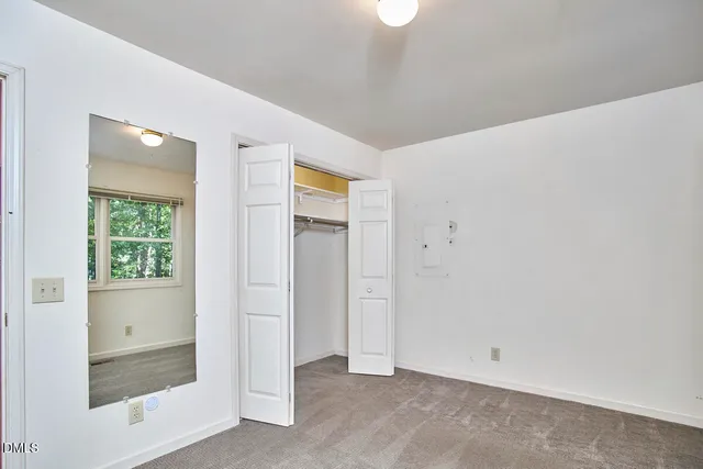 an empty room with windows and closet