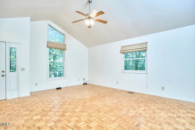 an empty room with a window and a fan