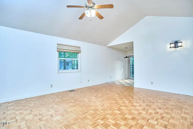 an empty room with a window and a ceiling fan