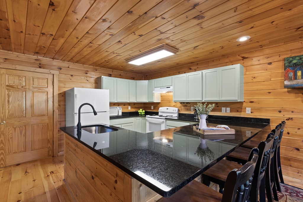 96 Holiday Court Ellijay, GA 30540 - Photo 17 of 51 a kitchen with granite countertop a table chairs stove and cabinets