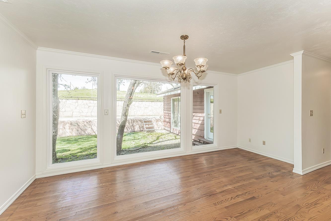 31638 Lodge Road Auberry, CA 93602 - Photo 14 of 90 a view of an empty room with wooden floor and a window