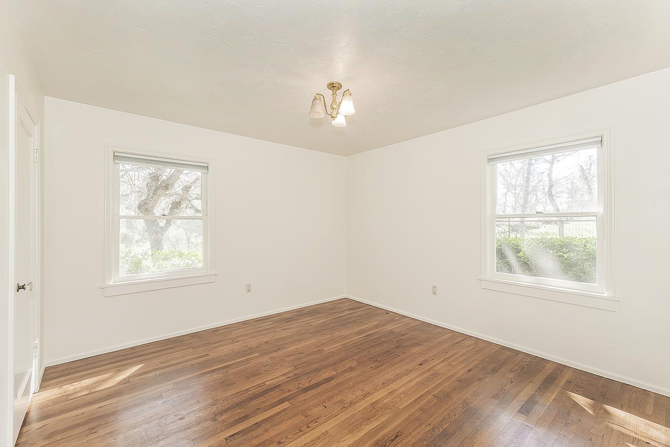 31638 Lodge Road Auberry, CA 93602 - Photo 34 of 90 an empty room with wooden floor ceiling fan and windows