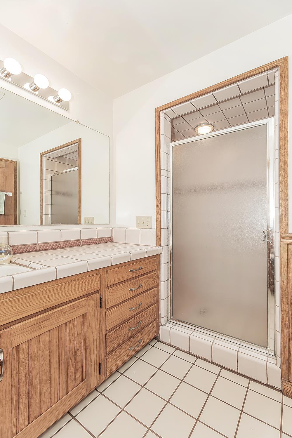 31638 Lodge Road Auberry, CA 93602 - Photo 37 of 90 a bathroom with a shower sink and mirror
