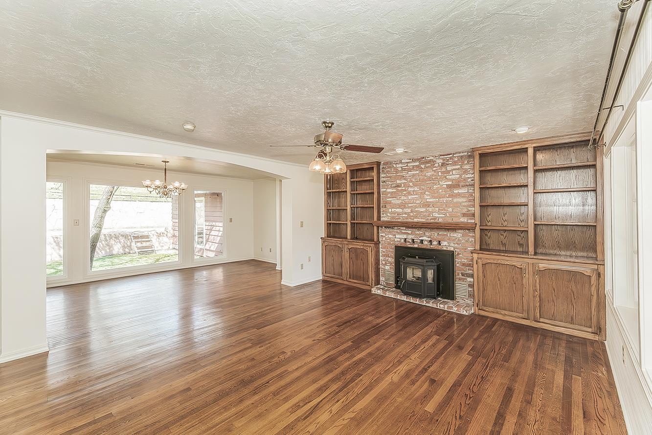 31638 Lodge Road Auberry, CA 93602 - Photo 10 of 90 an empty room with wooden floor fireplace and windows