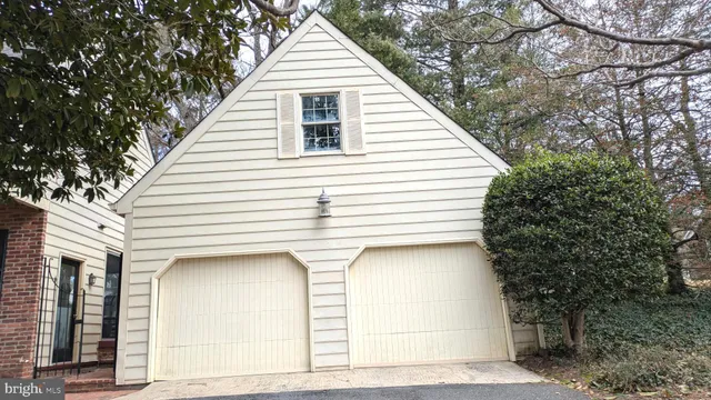 a view of a white house with large tree