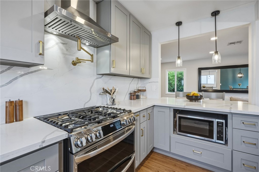 2028 Chesson Street Duarte, CA 91010 - Photo 13 of 66 Chef’s kitchen with solid quartz counters, slab backsplash to the ceiling, pot filler, LG stainless package with double oven, and custom cabinets/drawers
