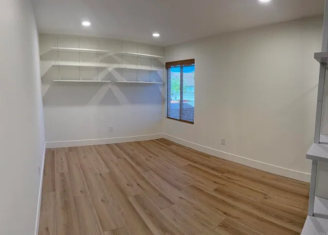 a view of an empty room with closet and a window
