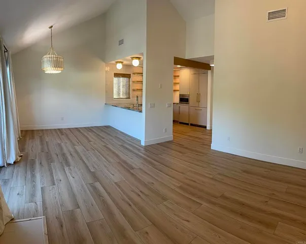 an empty room with wooden floor and mirror