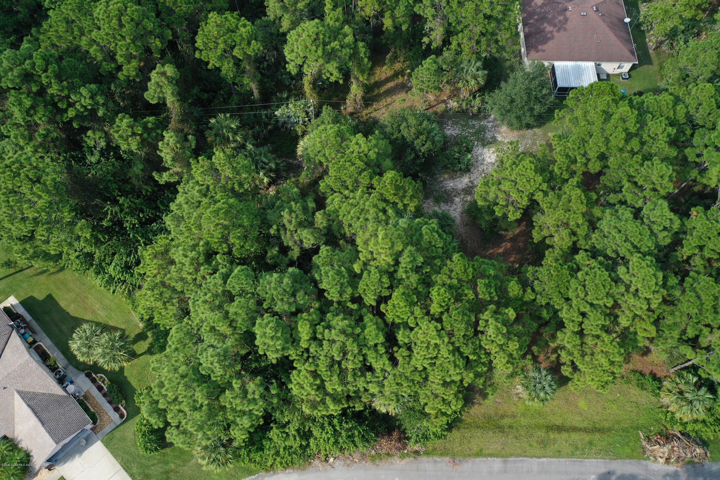 730 Gibbons Road Southwest Palm Bay, FL 32908 - Photo 2 of 11 an aerial view of residential house with outdoor space and trees all around