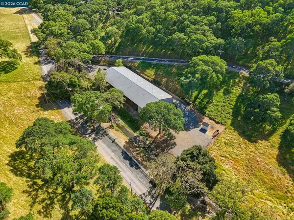 an aerial view of a house with a yard and green space