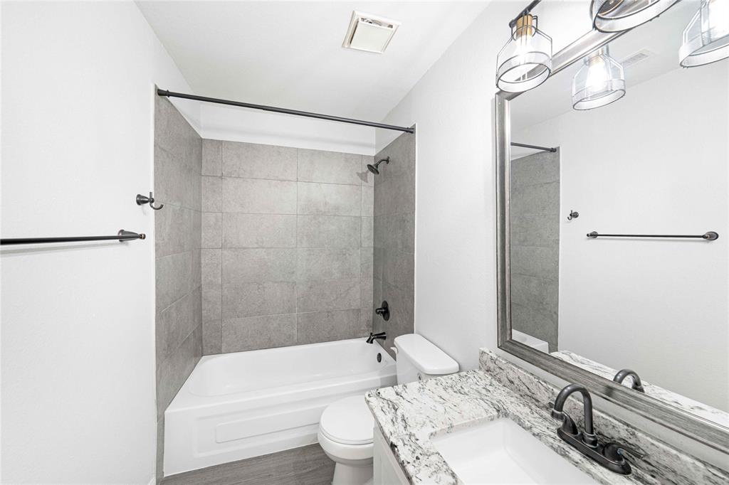 2200 East Trinity Mills Road, Unit 510 Carrollton, TX 75006 - Photo 11 of 17 a bathroom with a granite countertop sink mirror toilet and bathtub