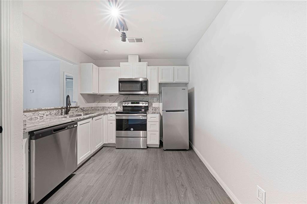 2200 East Trinity Mills Road, Unit 510 Carrollton, TX 75006 - Photo 3 of 17 a kitchen with stainless steel appliances a refrigerator stove and microwave