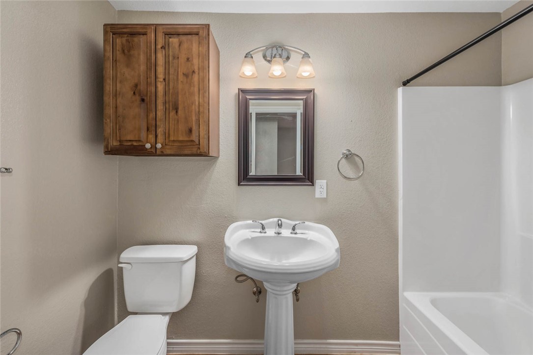 3914 Old College Road Bryan, TX 77801 - Photo 11 of 12 a bathroom with a toilet sink and mirror