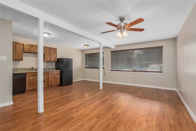 a view of an empty room with window and wooden floor