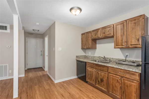 a kitchen with a sink a cabinets and wooden floor