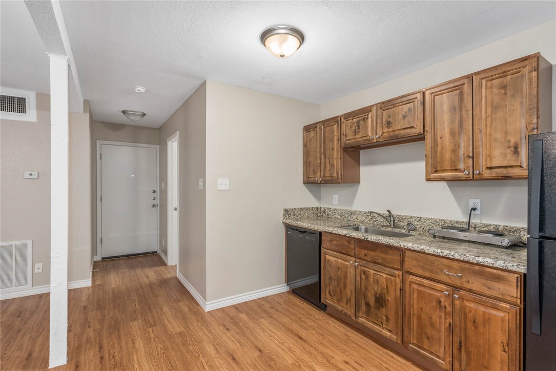 3914 Old College Road Bryan, TX 77801 - Photo 8 of 12 a kitchen with a sink a cabinets and wooden floor