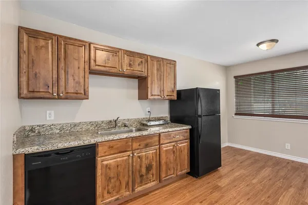 a kitchen with a sink a refrigerator and cabinets