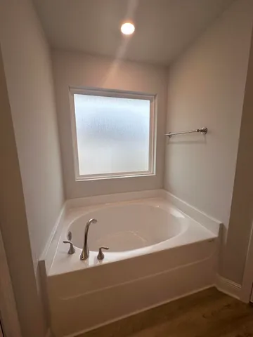 a bathroom with a bathtub and a window