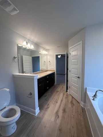 a bathroom with a double vanity sink toilet and mirror