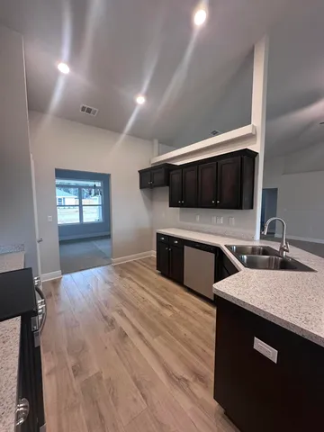 a kitchen with stainless steel appliances a stove microwave and sink